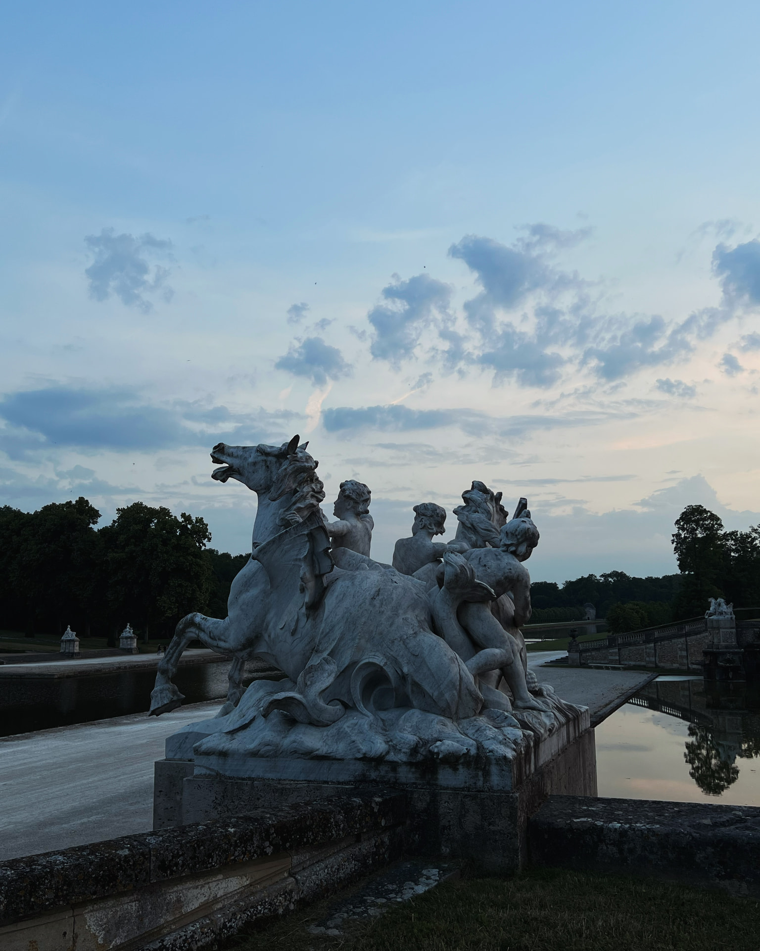 Classical marble sculpture of horses and figures at dusk — Musivo AI